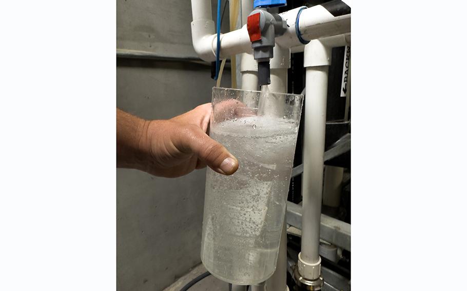 Epic Cleantec operations director Ryan Pulley fills a beaker with gray water cleaned to drinking water standards, to be reused for flushing toilets, laundry, and irrigation at the San Francisco apartment tower it came from. 