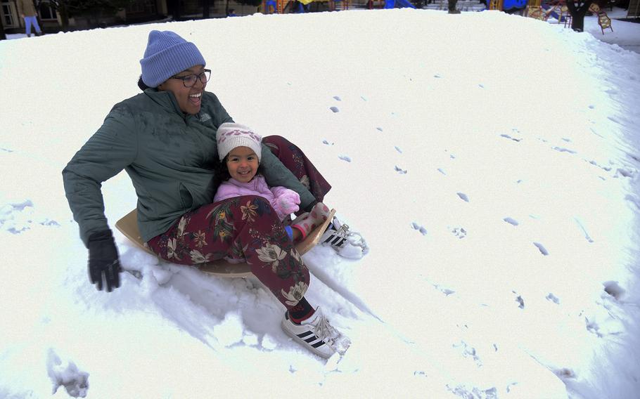 Elementary school teacher Eris Buritica and daughter Ella sled down a hill at Yokota Air Base, Japan, Tuesday, Feb. 6, 2024. 