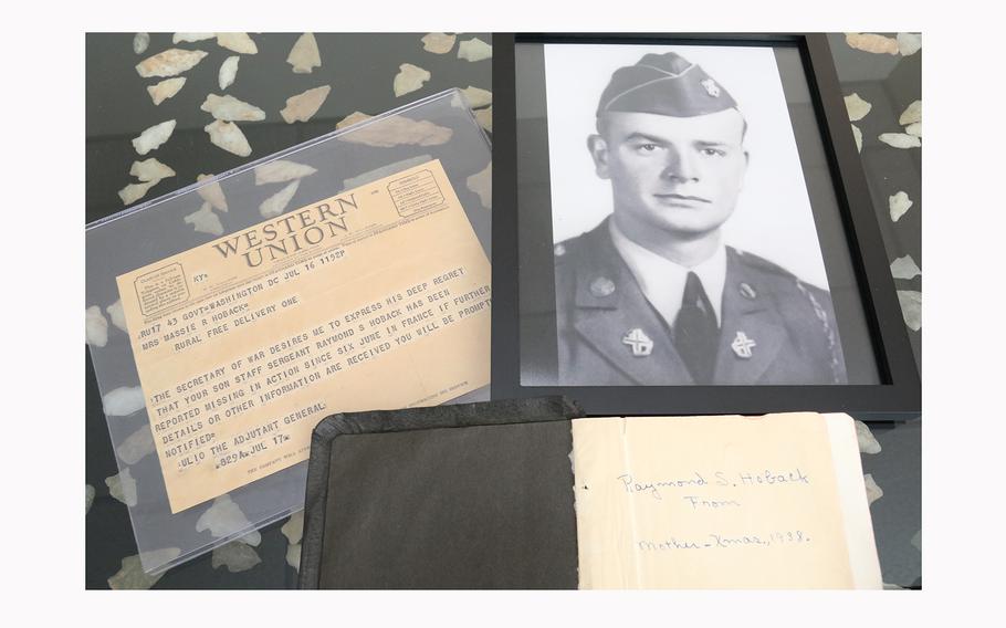 At left is the telegram notifying the Hoback family that Raymond Hoback was missing in action on D-Day. Top right is a photograph of Raymond Hoback. Below the photograph is his Bible, recovered by another soldier and sent home to his parents. 