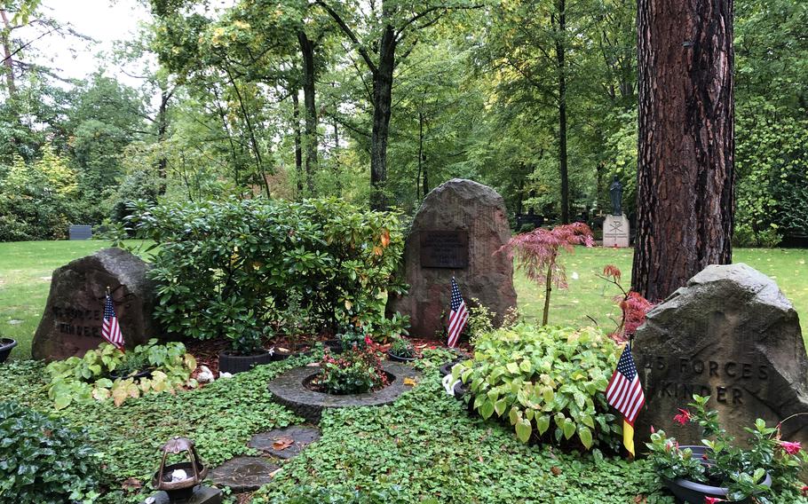 The Kindergraves memorial at Hauptfriedhof Kaiserslautern is decorated with American and German flags. Gravestones mark the burial spots of 451 American infants who died between 1952 and 1971 while their families were stationed in or near Kaiserslautern,  Germany.