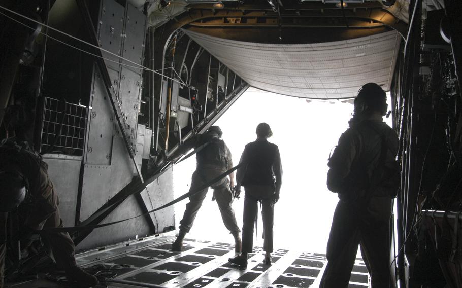 U.S. Ambassador to Senegal Janice L. Jacobs (center) stands near the edge of a C-130 Talon jumping platfrom as she watches a contingent of U.S. Army Special Forces soldiers skydive. She is flanked by two members of the U.S. Air Force 352nd Special Operations Group. 