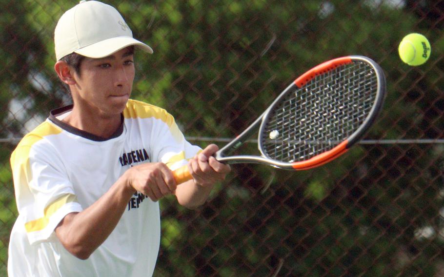 Kadena's Nathan Asato hits a backhand shot during Wednesday's Okinawa doubles tennis matches. Asato and his partner Iain Stanley beat Kubasaki's Canaan Jones and Jacy Fisk 8-6.