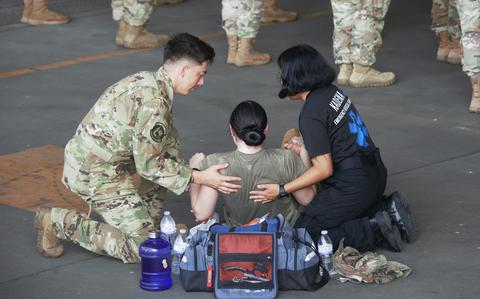 An airman is treated after collapsing from heat during the 18th Wing change-of-command ceremony at Kadena Air Base, Okinawa, Thursday, July 6, 2023. 