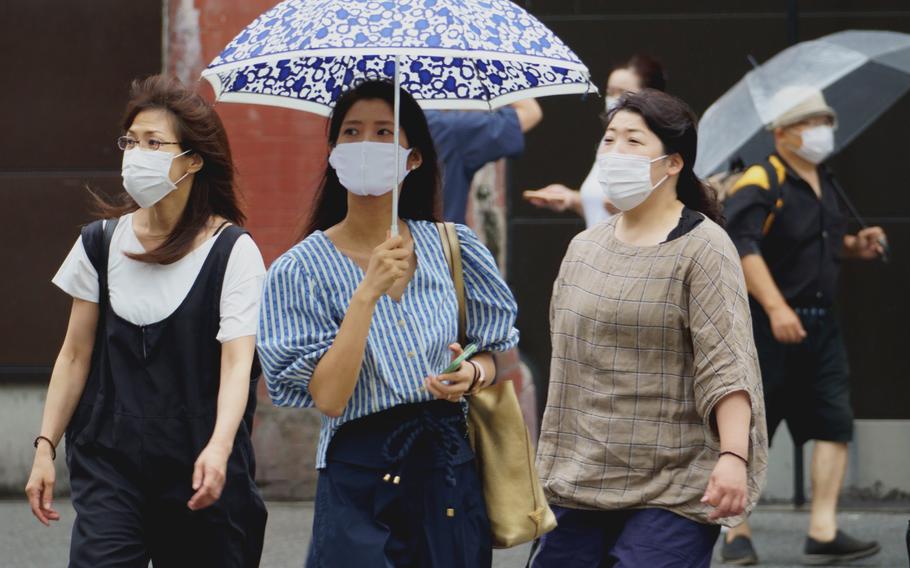 Pedestrians in central Tokyo wore masks as protection agains the coronavirus on Aug. 13, 2021.