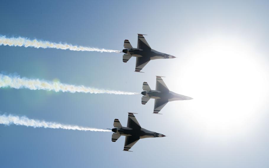 Three airplanes fly in formation in front of the sun