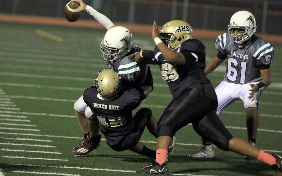 Singapore quarterback Heathe Billingslea is hauled down by Humphreys' JaLeil McKinney and Christopher Stevens.