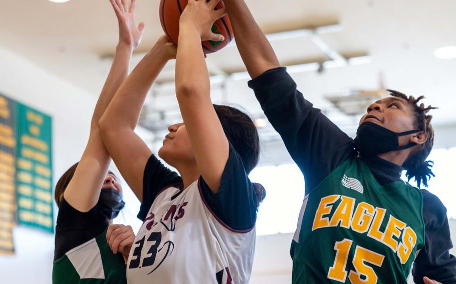 Robert D. Edgren’s Jaylie Johnson blocks a shot by Zama’s Kierstyn Aumua during Saturday’s DODEA-Japan girls basketball game. The Eagles won 30-25.