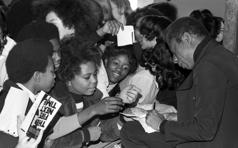 Students at Ludwigsburg High School scramble to get an autograph from James Baldwin. The novelist, essayist and playwright was in town for the Black Literature and Culture Week.