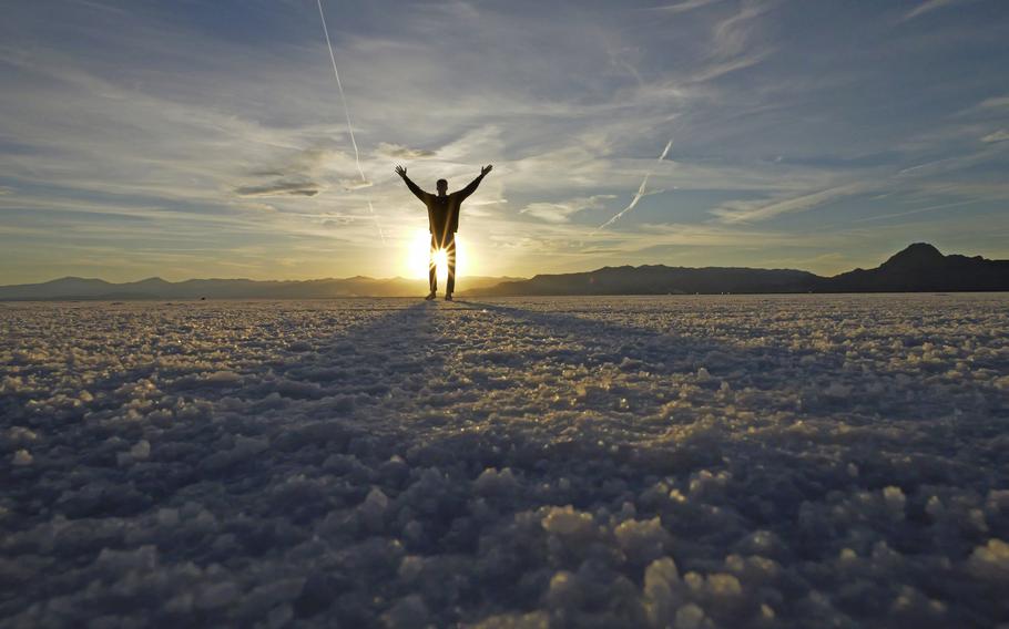 A visitor to Bonneville Salt Flats poses for photographs Saturday, Oct. 8, 2022, near Wendover, Utah. The salt is thinning as climate change drags the West into its third decade of drought, yet it’s unclear how that affects the seasonal flood patterns the landscape relies on to maintain its size and footprint.