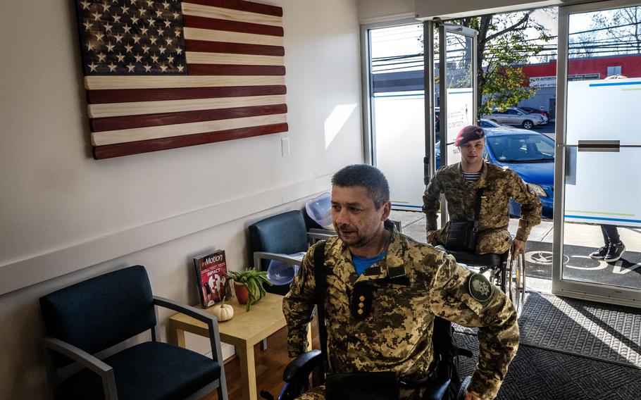 Ruslan Tyshchenko, foreground, and Aleksander Fedun, both Ukrainian soldiers getting replacement limbs, arrive at Medical Center Orthotics and Prosthetics in Silver Spring, Md. 