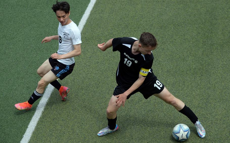 Humphreys' Garrett Smith tries to settle the ball as Osan's Justin Towne runs past.