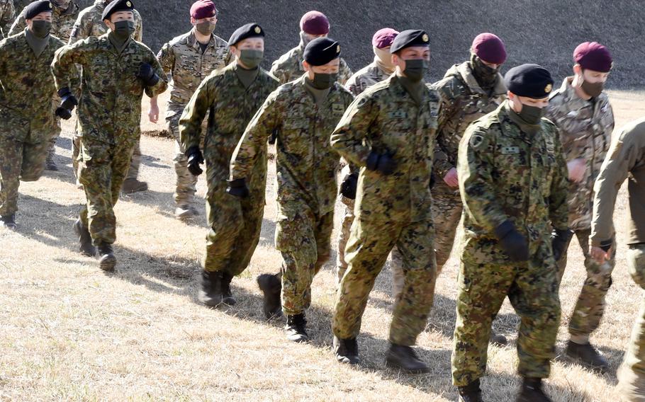Paratroopers jog in fomation following the annual New Year's Jump at Camp Narashino in Chiba prefecture, Japan, Sunday, Jan. 8, 2023.