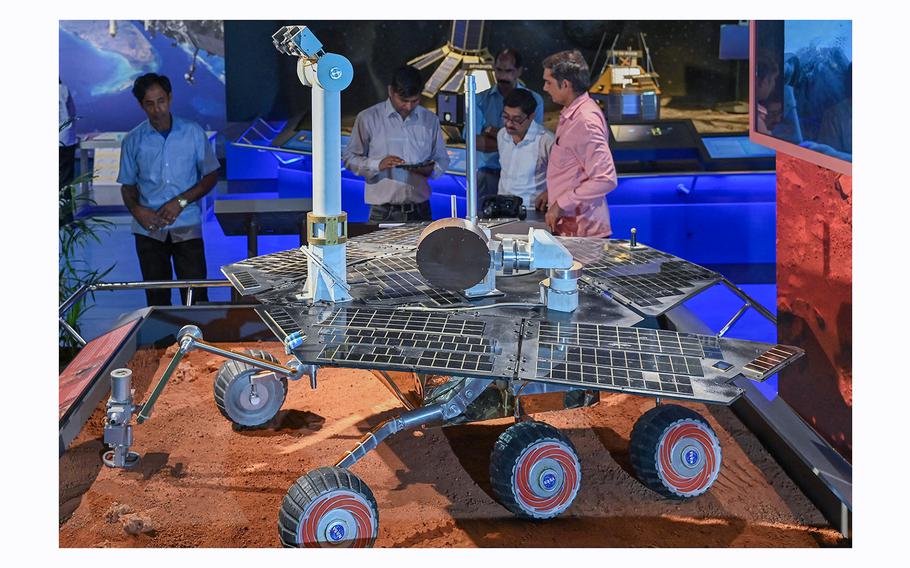 Visitors look at a replica of NASA's Mars Rover Opportunity during its unveiling ceremony at the Visvesvaraya Industrial and Technological Museum in Bengaluru on June 1, 2023. 
