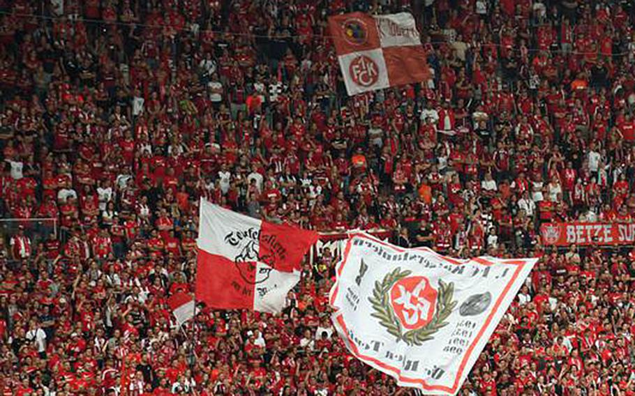 Fans dressed in FC Kaiserslautern apparel cheer on the soccer team during a game at Fritz Walter Stadium. 
