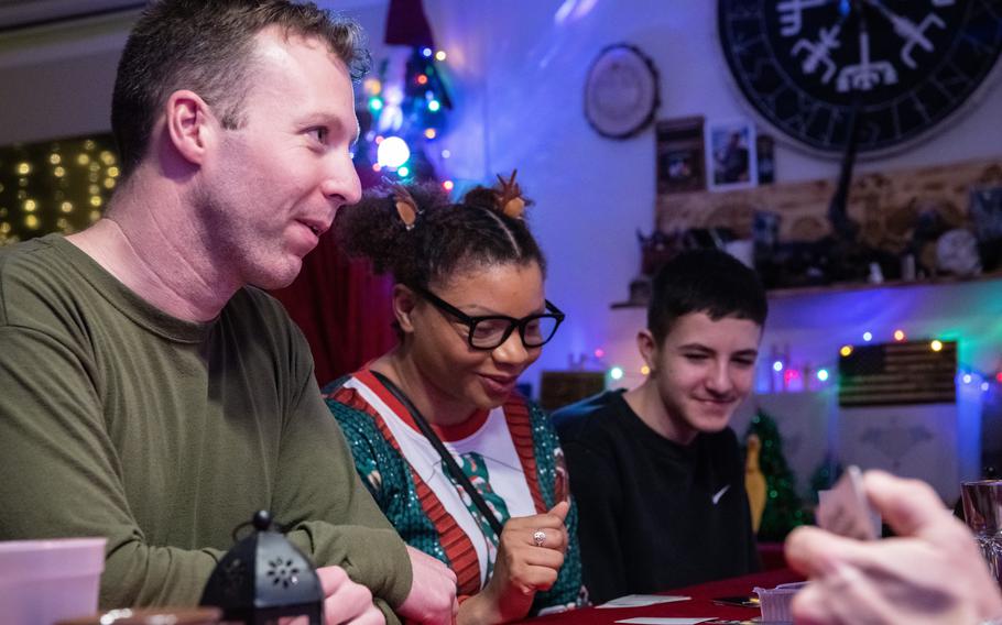 Army Staff Sgt. Matthew Fox, from left, Staff Sgt. Mary Porter and T.J. Buerger play Cards Against Humanity on Christmas Eve 2023. Fox was invited to spend the holiday with the Buerger family as part of Operation Good Cheer.