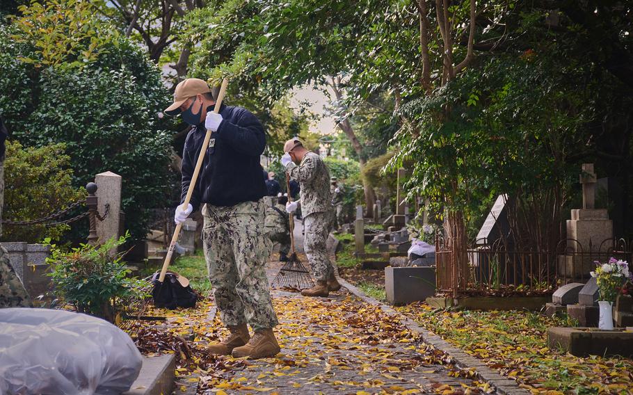 Sailors from Yokosuka Naval Base, Japan, clean up grounds dedicated to American veterans buried at Yokohama Foreign General Cemetery, Wednesday, Nov. 10, 2021.