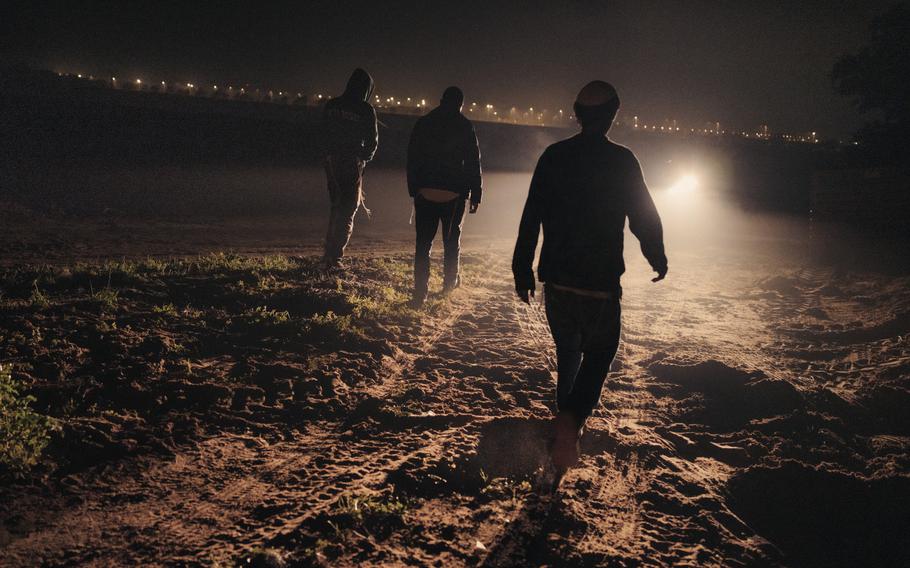 Yosef de Bresser, 22, right, and others return to the car after scouting a dirt road to reach Kerem Shalom without being spotted by Israeli police.