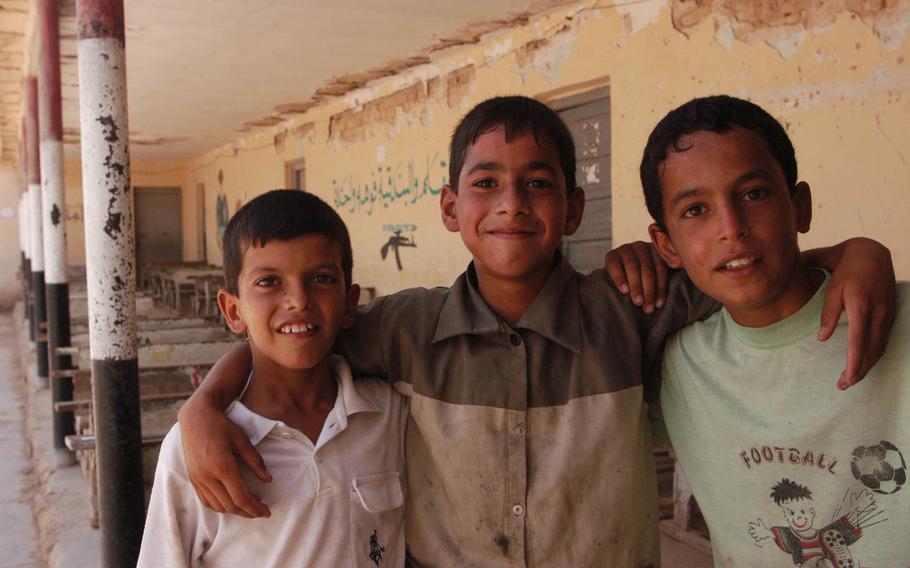 Children pose in a damaged hallway