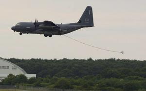 A refueling hose trails behind an HC-130J Combat King II aircraft as it approaches the runway.