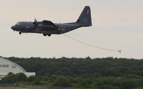 A refueling hose trails behind an HC-130J Combat King II aircraft as it approaches the runway.