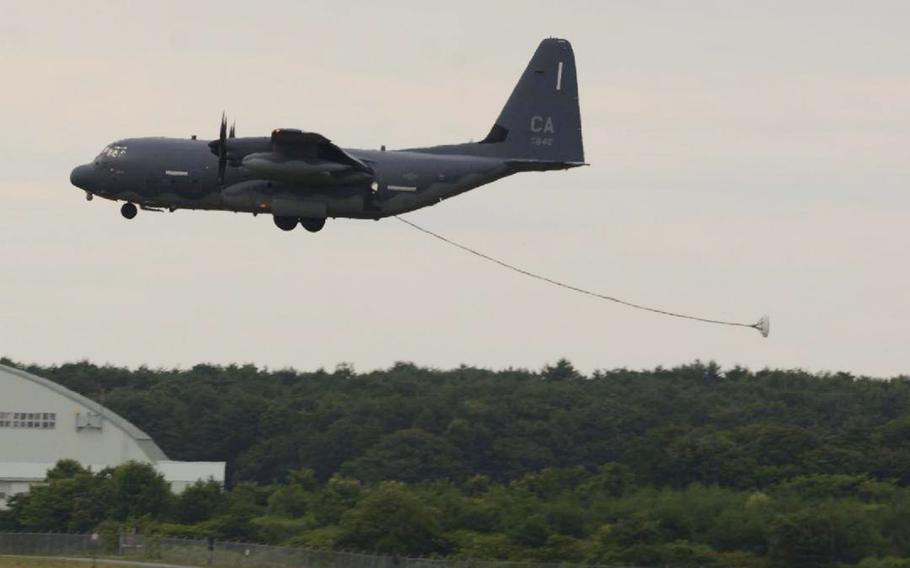 A refueling hose trails behind an HC-130J Combat King II aircraft as it approaches the runway.