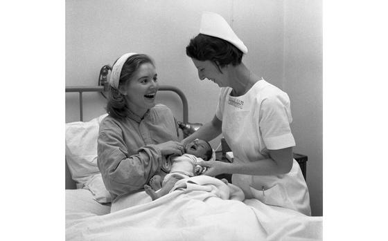 Chief nurse Maj. Ruth Steenburgh puts a newborn baby into the arms of its happy mother at the 97th U.S. Army Hospital in Frankfurt. 
The week of April 3-7, 2023 marks World Health Worker week and to recognize and celebrate health care workers keeping the military community healthy around the globe, we dug into our archives to show you the men and women of the maternity ward at the 97th General Hospital in Frankfurt from 1957. Check out more photos - including a photo of special anteroom for the pacing and fretting dads to be - plus the original article here. 

Looking for Stars and Stripes’ historic coverage? Subscribe to Stars and Stripes’ historic newspaper archive! We have digitized our 1948-1999 European and Pacific editions, as well as several of our WWII editions and made them available online through https://starsandstripes.newspaperarchive.com/

health care; obstetrics; gynecology; maternity care; pediatrics; 