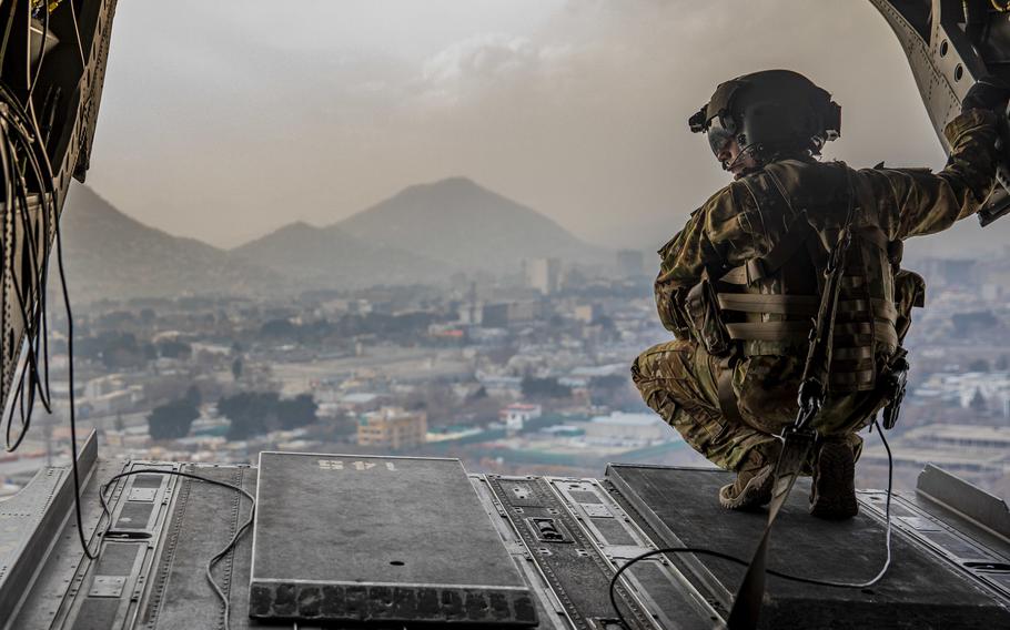 A U.S. soldier crouches at the back of a CH-47 Chinook during a flight over Kabul, Afghanistan on March 3, 2020. For years, there have been bounties on members of the Haqqani network, which the United States has branded as terrorists. Now they're in power in Kabul, after the Taliban took over in August 2021.