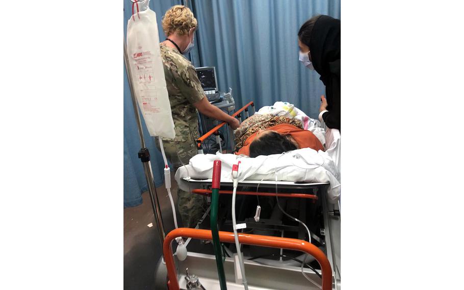 Dr. (Maj.) Elaina Wild, 379th Expeditionary Medical Group chief medical officer, examines an evacuee from Afghanistan before she gives birth at Al Udeid Air Base, Qatar, Aug. 28, 2021. 