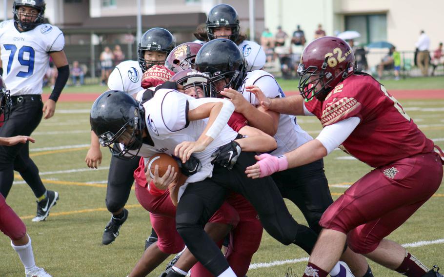 Osan's Josh Low is wrapped up by three Matthew C. Perry defenders.