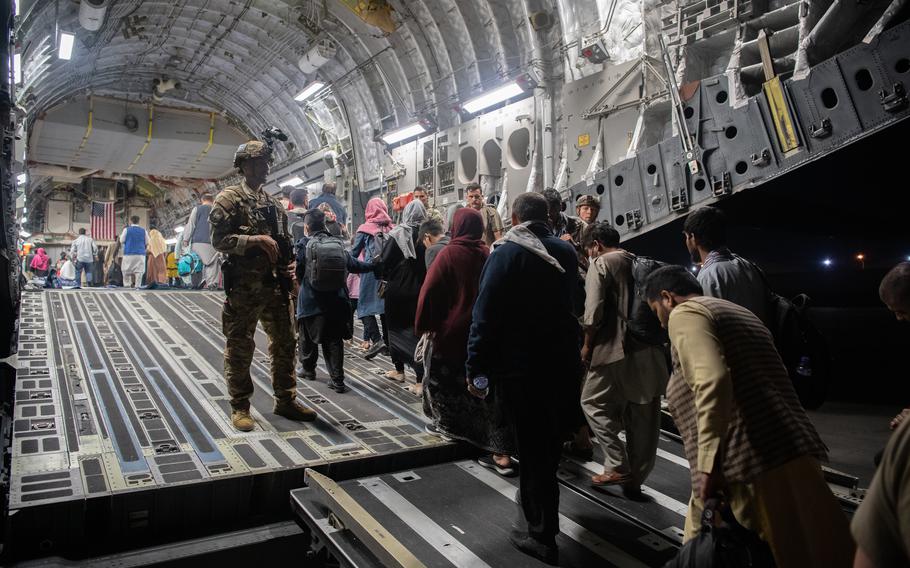 Afghan evacuees  board a U.S. Air Force C-17 Globemaster III at the international airport in Kabul, Afghanistan, on Aug. 22, 2021.