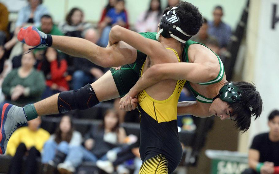 Kadena 114-pounder Cedric Ferguson sends Kubasaki's Noah Starr airborne during Wednesday's Okinawa wrestling dual meet. Ferguson won by technical fall 18-8 in 5 minutes, 43 seconds, and the Panthers won the meet 34-28 to go 4-0 over the Dragons on the season.