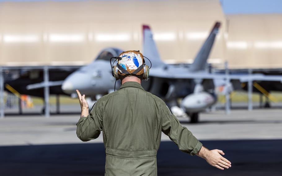 Marine Corps Cpl. David Rarrick, a mechanic with Marine Fighter Attack Squadron 232, guides an F/A-18D at Marine Corps Air Station Iwakuni, Japan, Sept. 24, 2023. 