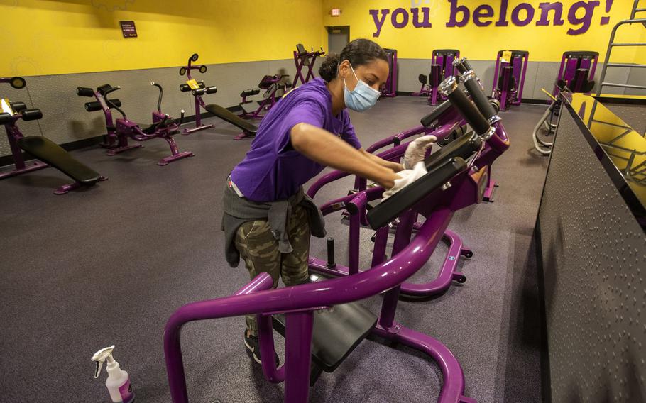 Lenterra Daniels, an employee at Planet Fitness on Imperial Highway in Inglewood, Calif., disinfects an abdominal resistance machine on March 15, 2021. 
