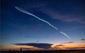 The launch of SpaceX Falcon 9 rocket with 22 Starlink satellites is viewed from Huntington Beach, California, at dusk after taking off from Vandenberg Space Force Base on March 18, 2024.