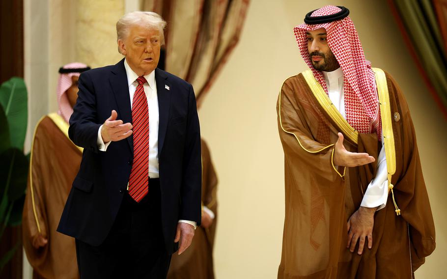 The leaders of the U.S. and Saudi Arabia side by side, with both gesturing their right hands outward in the same direction.