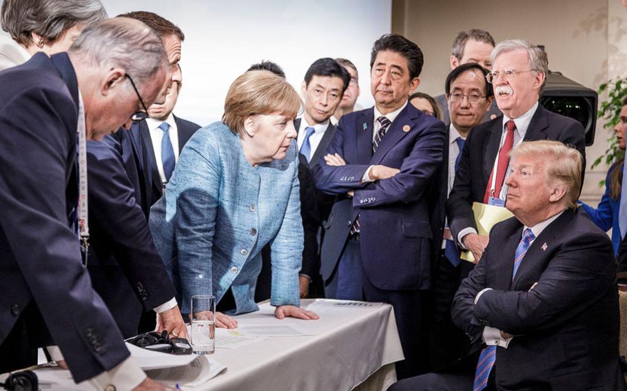 German Chancellor Angela Merkel deliberates with US president Donald Trump on the sidelines of the official agenda on the second day of the G7 summit on June 9, 2018 in Charlevoix, Canada. 