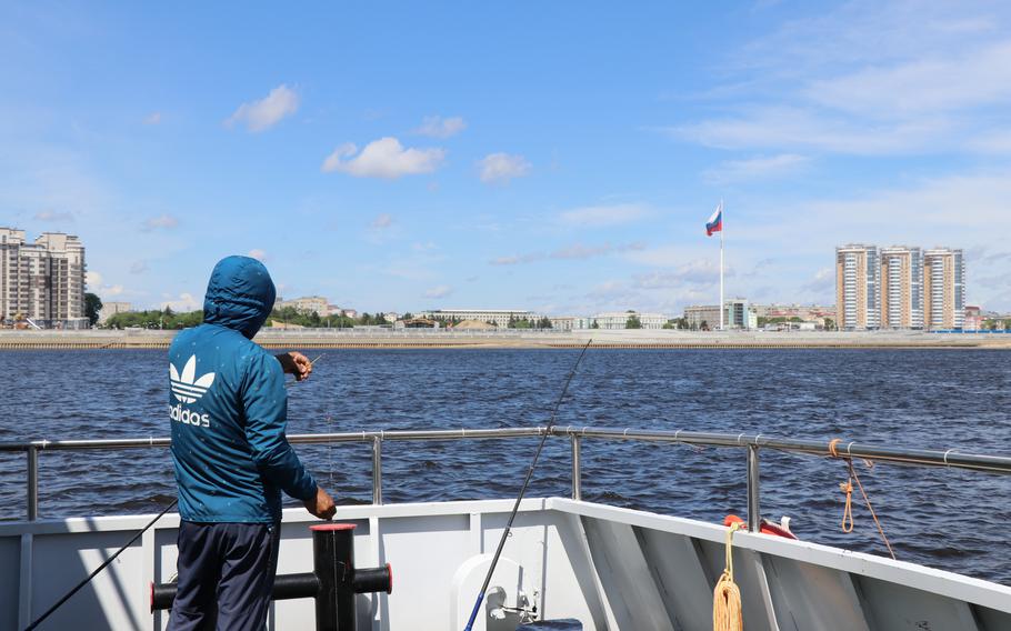 A man from Heihe, China, fishes on the Amur River within sight of Blagoveshchensk, Russia, on June 17, 2022. 