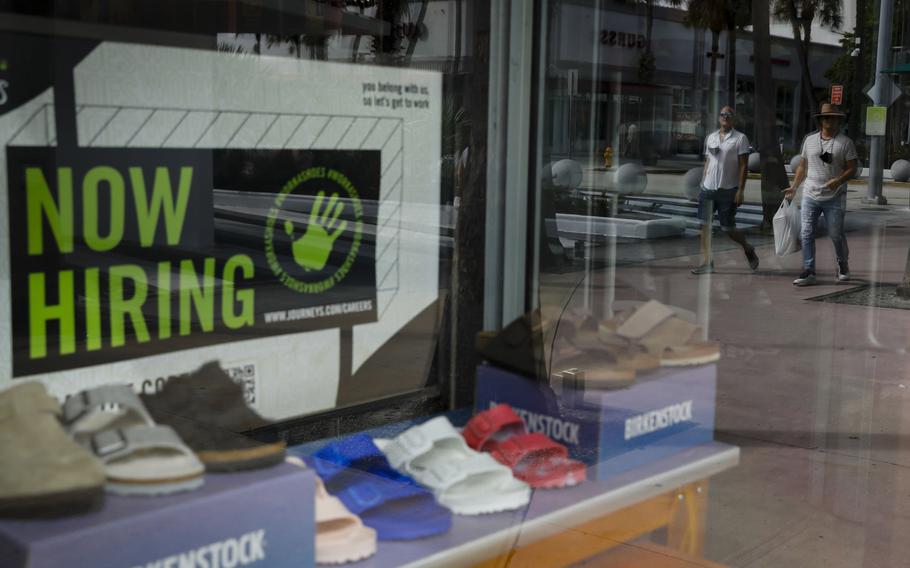 A "Now Hiring" sign outside a shoe store in Miami on Oct. 23, 2021. 