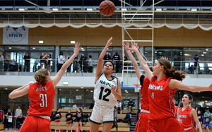 Naples’ Anais Navidad aims for the basket between AOSR’s Charlotte Burgas-Sims, left, and Natalia DiMatteo in the girls Division II final at the DODEA-Europe basketball championships in Wiesbaden, Germany, Feb. 17, 2024. The Wildcats took the title, beating AOSR 48-29.