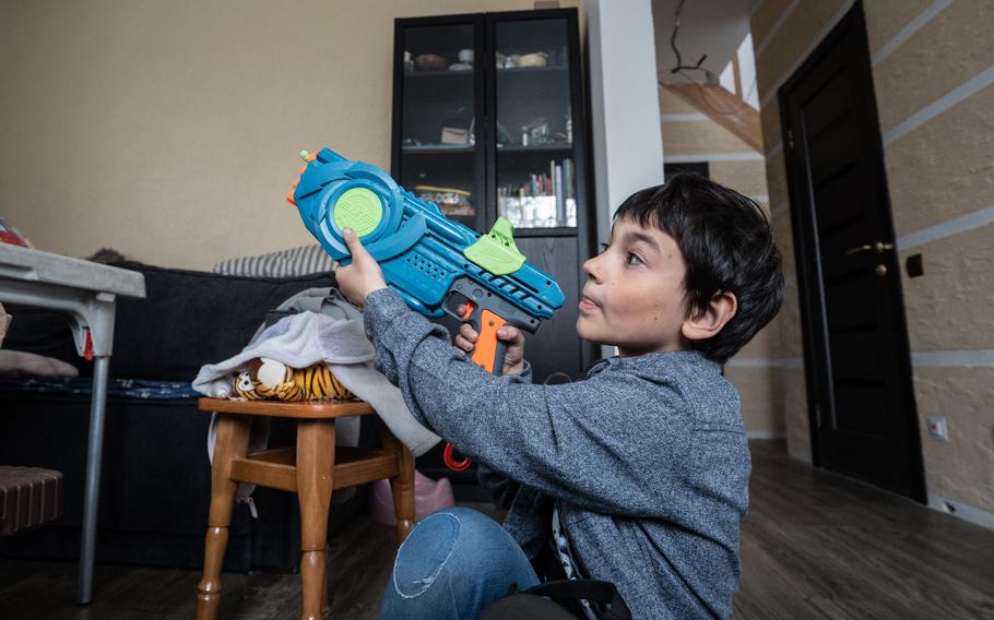 Davyd Stohniienko-Vyhovska plays with a toy gun at his grandfather's house in Kyiv. 