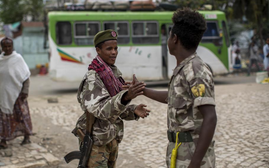 Fighters loyal to the Tigray People's Liberation Front greet each other on the street in the town of Hawzen, then-controlled by the group, in the Tigray region of northern Ethiopia, on May 7, 2021. The rural town is a microcosm of the challenge facing Prime Minister Abiy Ahmed - and a warning that the war here is unlikely to end anytime soon.