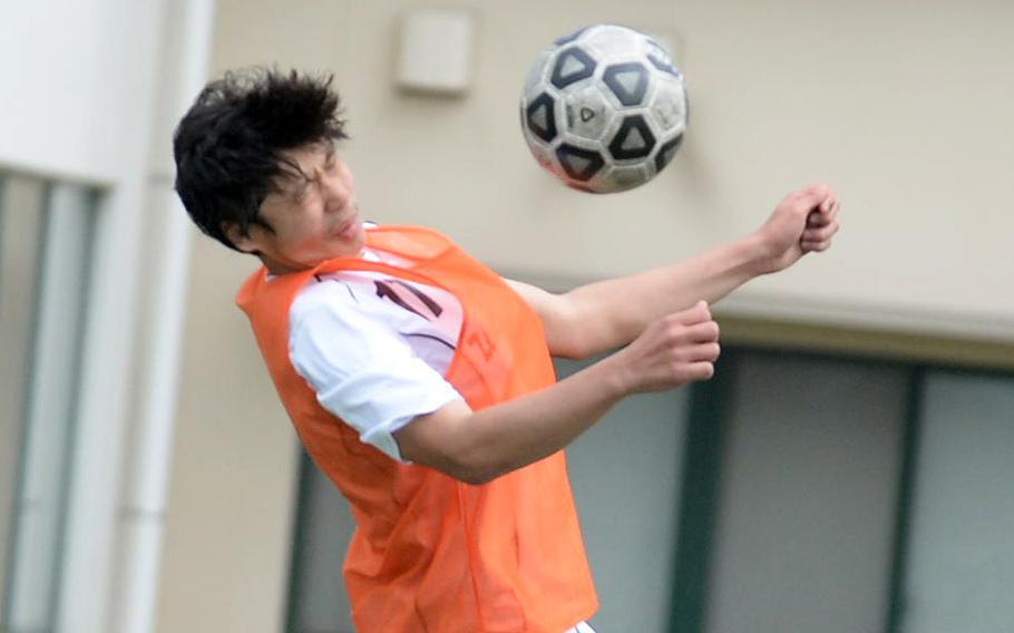 Zama’s Justin Knutson plays the ball off his chest against E.J. King during Saturday’s DODEA-Japan boys soccer match. The Trojans won 4-0.