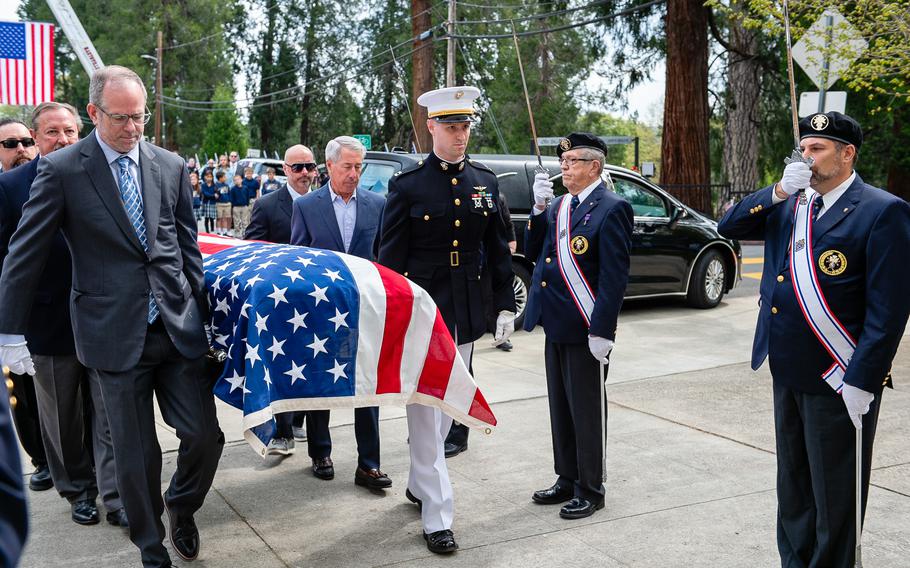 Pallbearers carry the casket of retired Lt. Cmdr. Lou Conter into the St. Patrick Catholic Church for his memorial service.