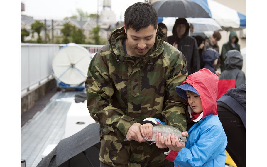 Nicholas Trans, left, hauled in the first rainbow trout of the  inaugural Sakana Trout Fishing Derby at Yokota Air Base, Japan, April 15, 2023. 