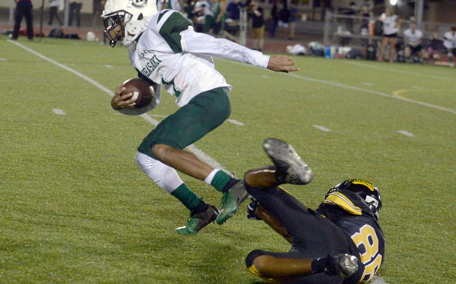 Elijah Ferrell-Ayers, Kubasaki's third quarterback, eludes the pursuit of Kadena's Jason Doll.