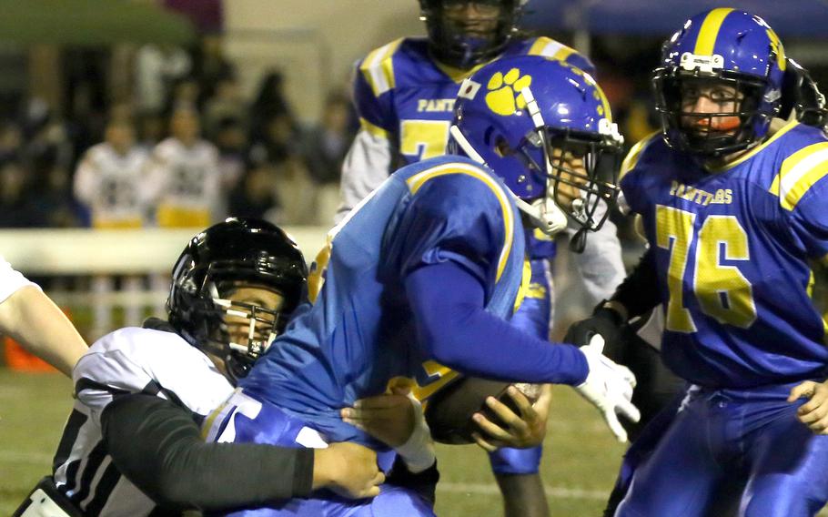 Yokota running back Noah Cruz drags a Zama defender with him.