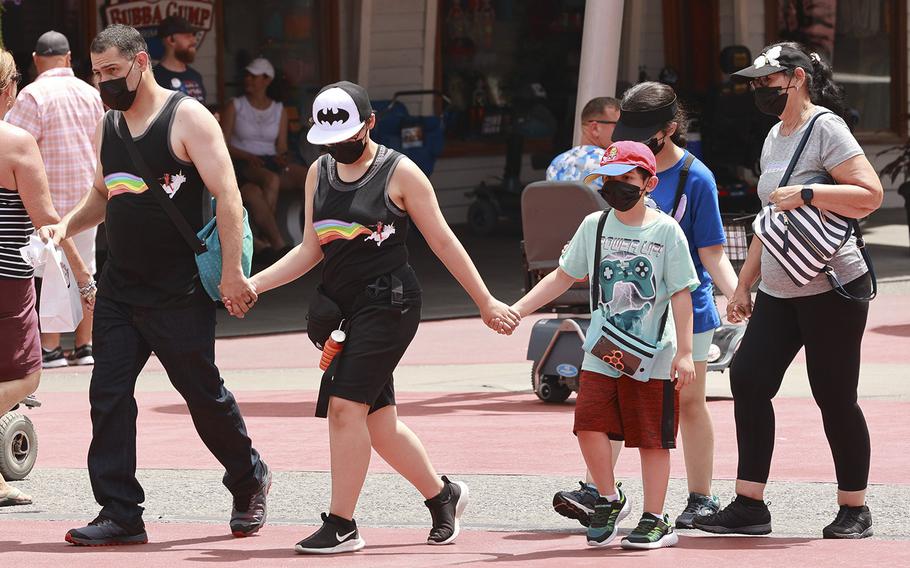 A masked family walks through Universal CityWalk on June 14, 2022, in Orlando, Florida. 