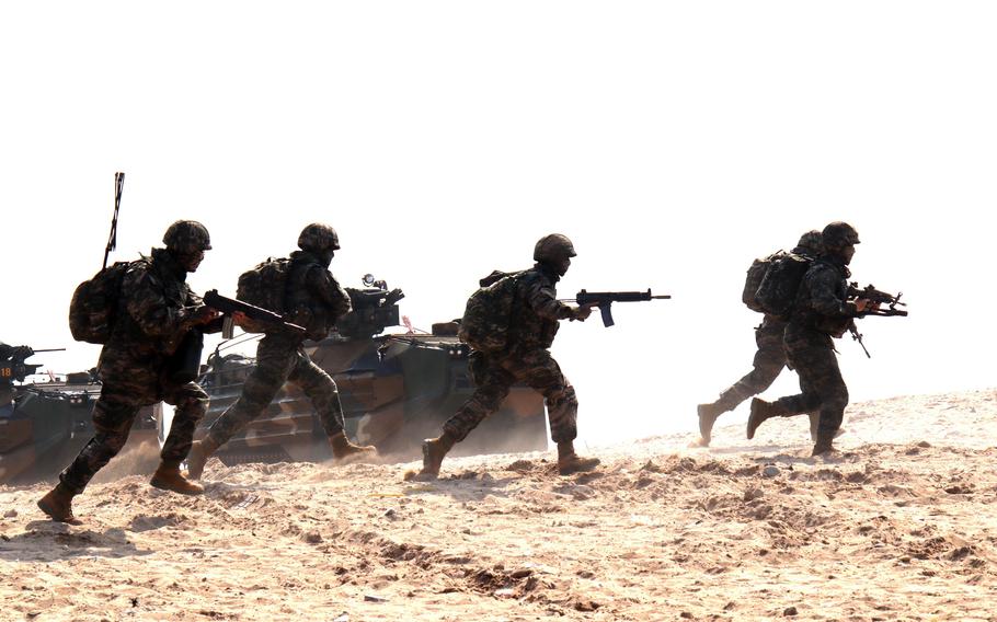 South Korean marines run toward cover during the Ssangyong exercise in Pohang, South Korea, March 29, 2023.