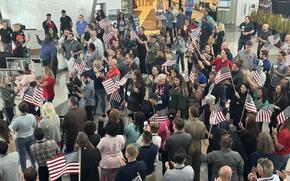 Flags greet World War II veterans as they arrive at American Airlines headquarters in Dallas-Fort Worth before heading to France for the 80th anniversary commemorations of D-Day in Normandy.