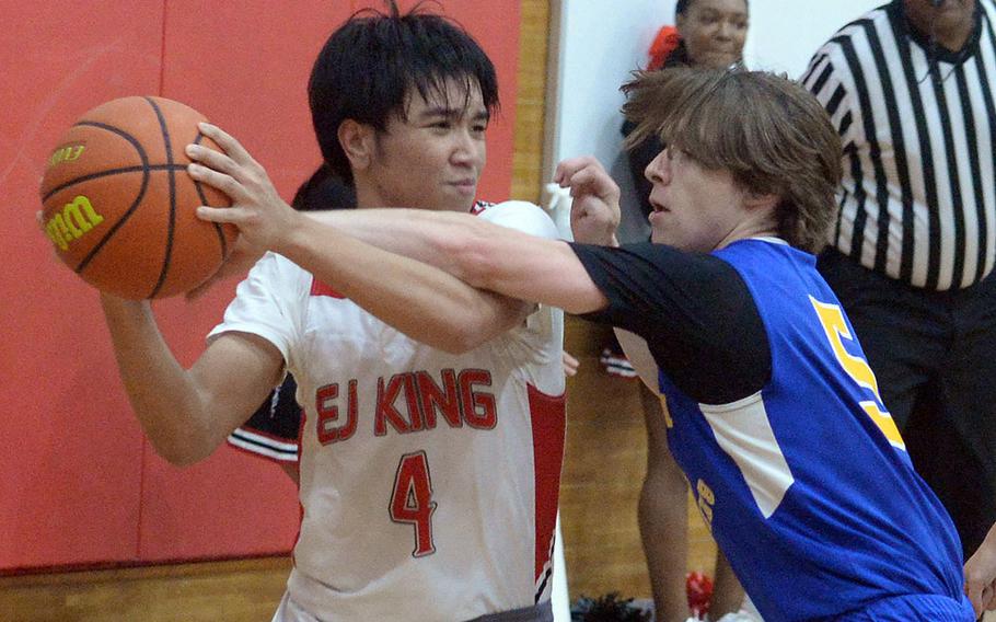 E.J. King's Shan Casimiro looks to pass against Yokota's Sergio Giddens during Friday's DODEA-Japan boys basketball game. The Panthers won 72-70.